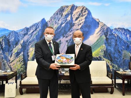 Premier Su (right) presents Slovak National Council Deputy Speaker Milan Laurenčik with a gilded plate depicting moth orchids on a colorful Taiwanese harvest scene.